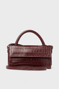 A Neely & Chloe burgundy embossed leather handbag with a crocodile texture, top handle, and long shoulder strap is displayed.