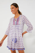 A woman wears a Ro's Garden cotton cover-up featuring purple star patterns, embroidered front details, and tassels on the hem and neckline—ideal as a vacation-ready tunic.