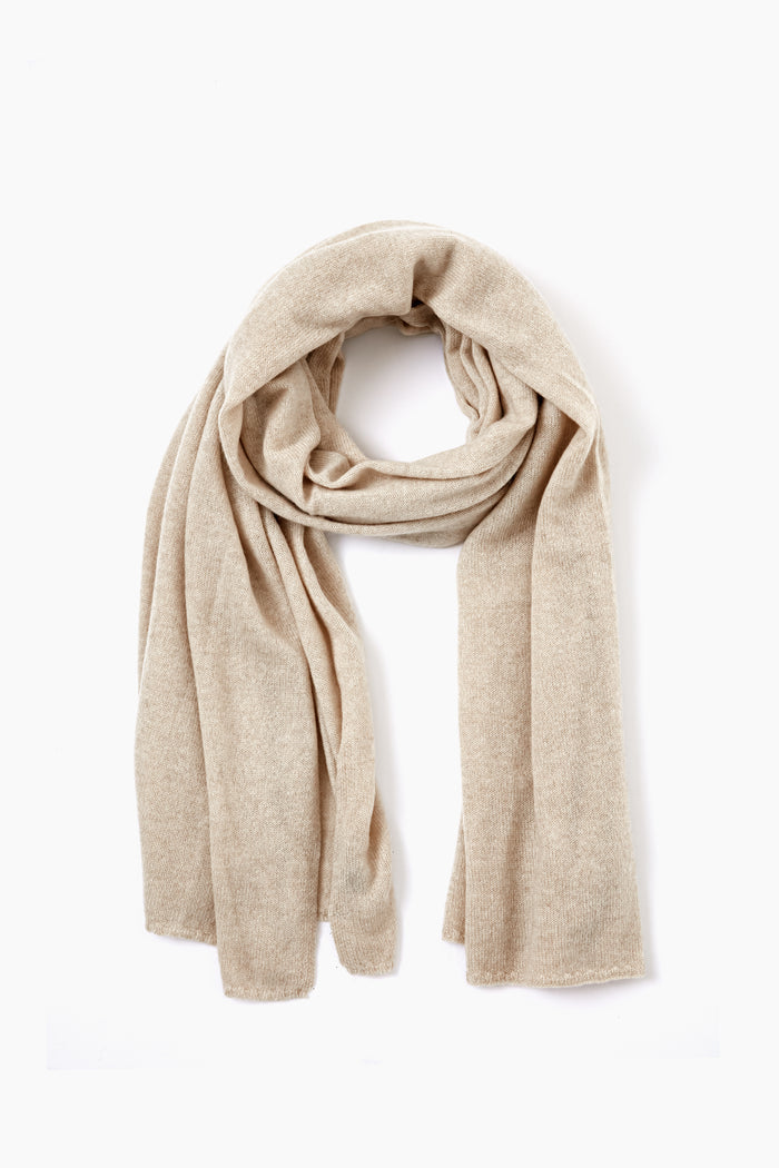 An Amicale beige knit luxury cashmere scarf is arranged in a loop, highlighting its soft texture and refined elegance.