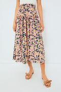 A woman stands confidently wearing a Moon River high-waisted pink floral maxi skirt, paired with a white top and tan sandals.