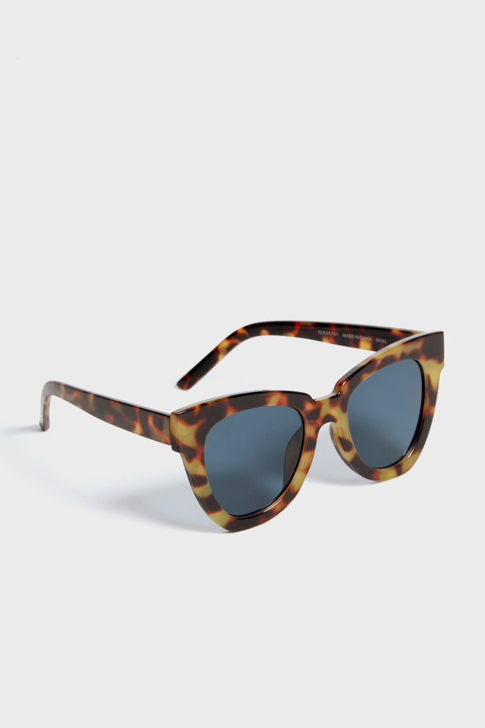Exclusive Tortoise Not Standard Sunglasses with a classic cat-eye shape, featuring tortoiseshell acetate frames and dark lenses, embodying an effortless, fun, high-end style.
