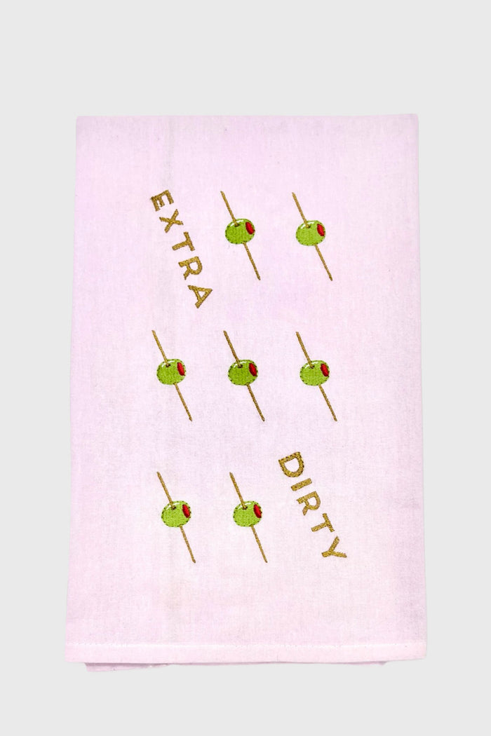 A unique gift: the Lynen embroidered tea towel showcases green olives on toothpicks and “EXTRA DIRTY” diagonally across soft white fabric.