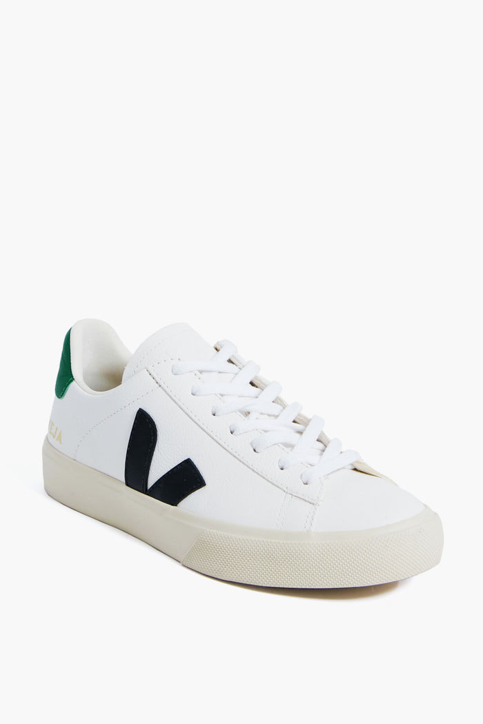 The VEJA white low-top sneaker is crafted from ecological materials, featuring a black V logo, green heel detail, and white laces—a stylish, sustainable choice.