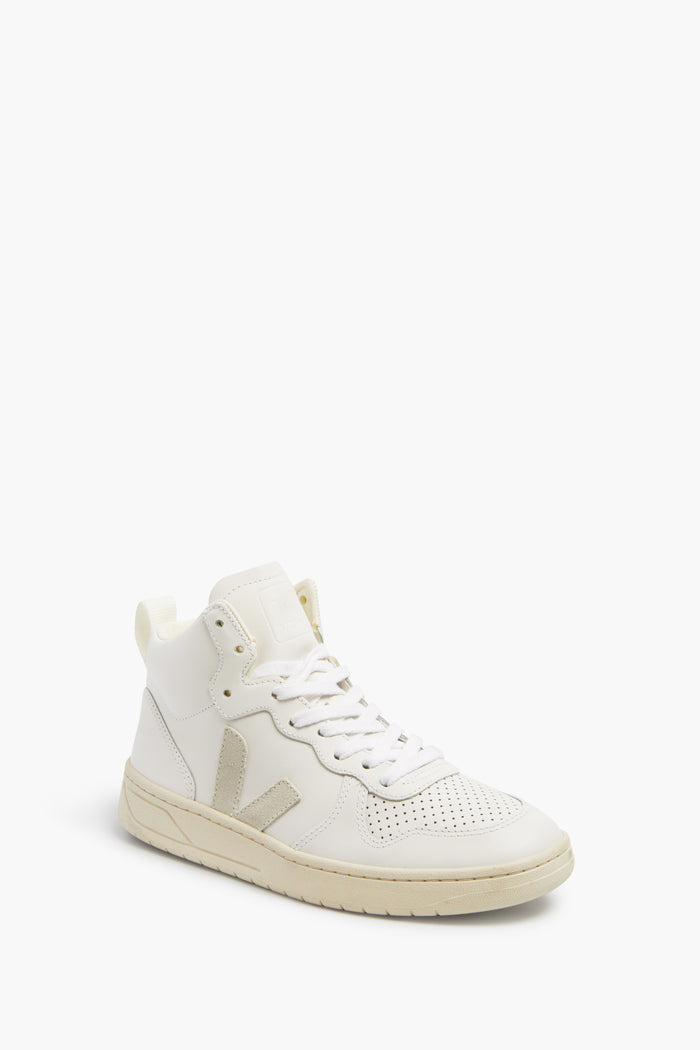 A single white high-top VEJA sneaker with white laces, a perforated toe, beige side V logo, and white rubber sole—crafted from sustainable materials.