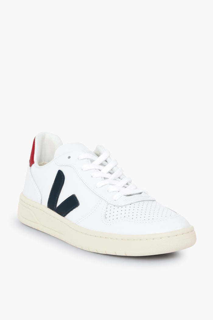 A sustainable white low-top VEJA sneaker featuring a perforated toe, black side V logo, white laces, beige sole, and a red heel accent—crafted from organic cotton.