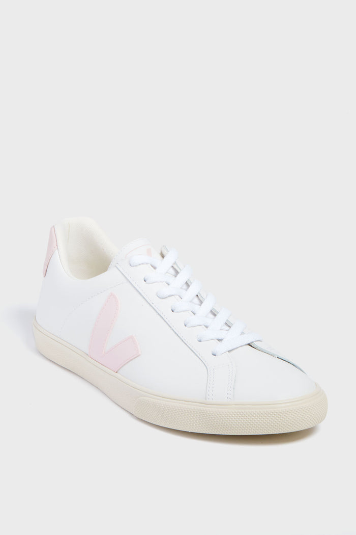 The VEJA sneaker features white organic cotton, light pink accents on the side logo and heel tab, white laces, and a beige rubber sole.