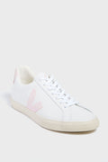 The VEJA sneaker features white organic cotton, light pink accents on the side logo and heel tab, white laces, and a beige rubber sole.