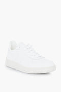 A white low-top VEJA sneaker featuring perforated toe details, white laces, and a white rubber sole—combining sustainable design with classic style.