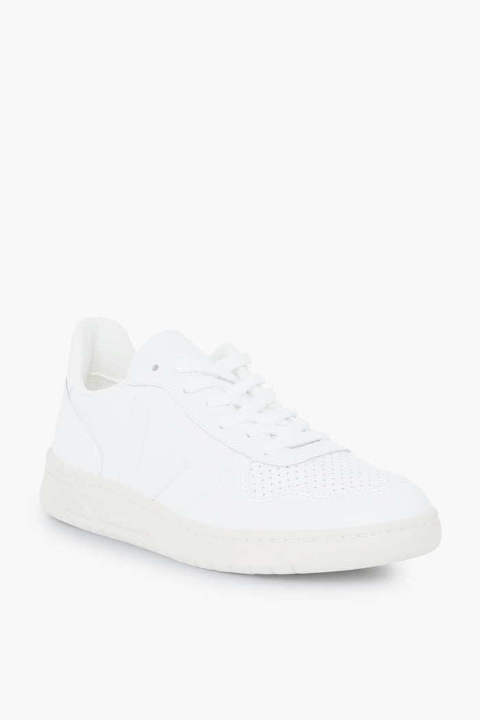 A white low-top VEJA sneaker featuring perforated toe details, white laces, and a white rubber sole—combining sustainable design with classic style.