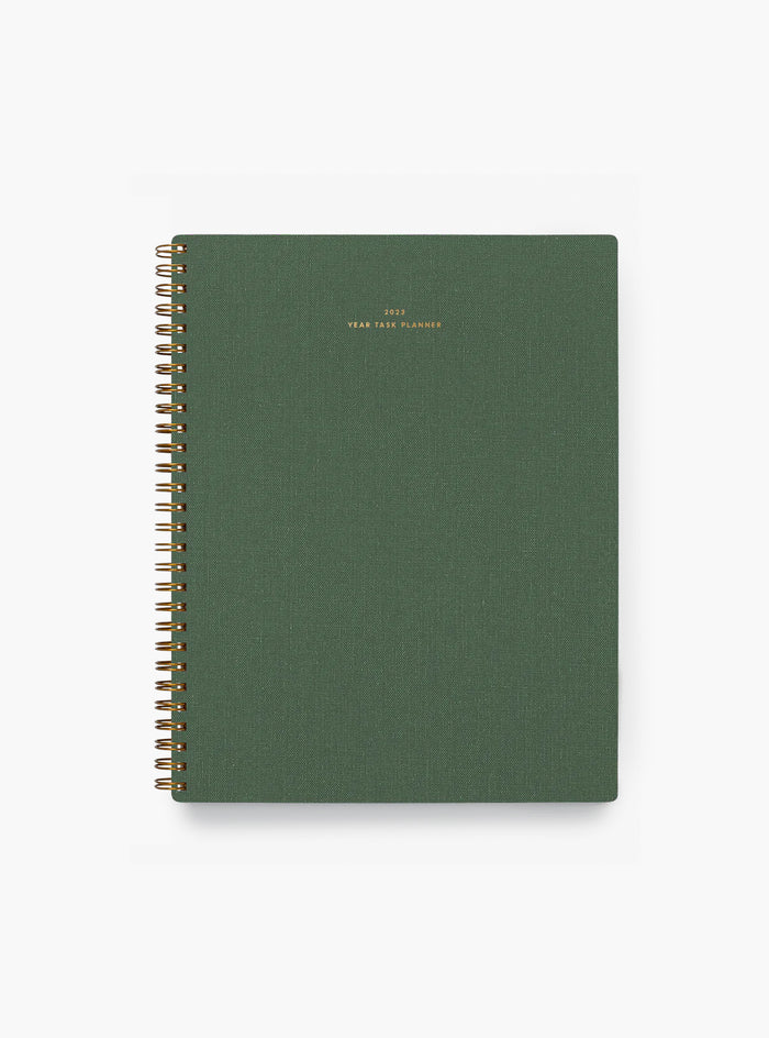 A green spiral-bound Yearly Task Planner from APPOINTED, featuring gold text on the cover that reads "2023 YEAR TASK PLANNER".