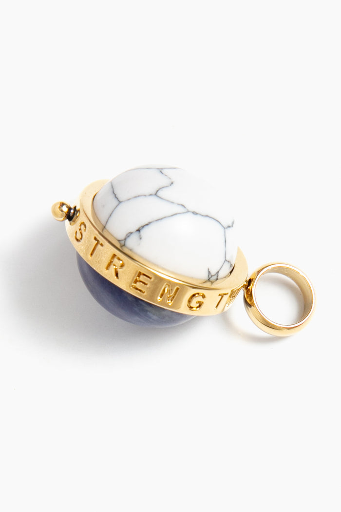 The Tuckernuck Jewelry 14k gold keychain features a circular white and dark blue stone, engraved with “STRENGTH” on the gold band—an inspiring wish charm for everyday motivation.