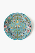 One Hundred 80 Degrees round ceramic plate with a detailed, symmetrical floral pattern in blue, green, pink, yellow, and black.