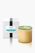 A lit French Lilac candle from LAFCO New York in a clear glass jar sits beside a white LAFCO New York box, bringing elegant home fragrance.