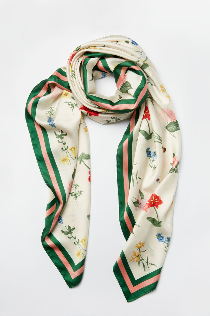 Tuckernuck Accessories' cream silk floral scarf features a custom print and green and pink striped border, making it a perfect luxury accessory.