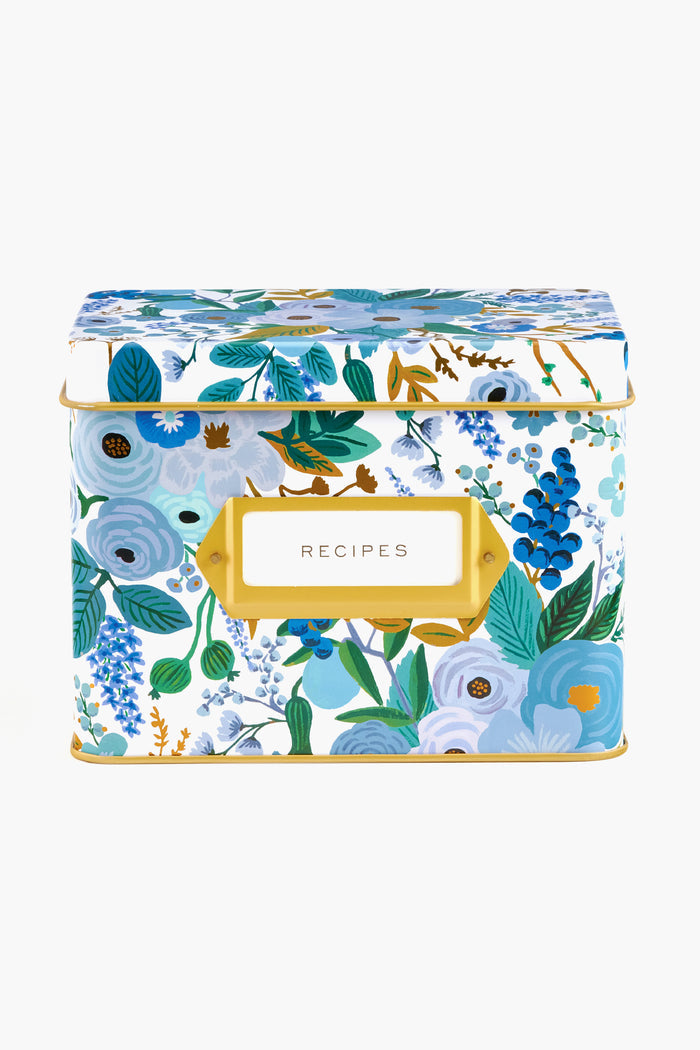A rectangular tin recipe box by Rifle Paper Co. features hand-painted blue and green florals, a gold label holder, and a front label that reads "RECIPES.