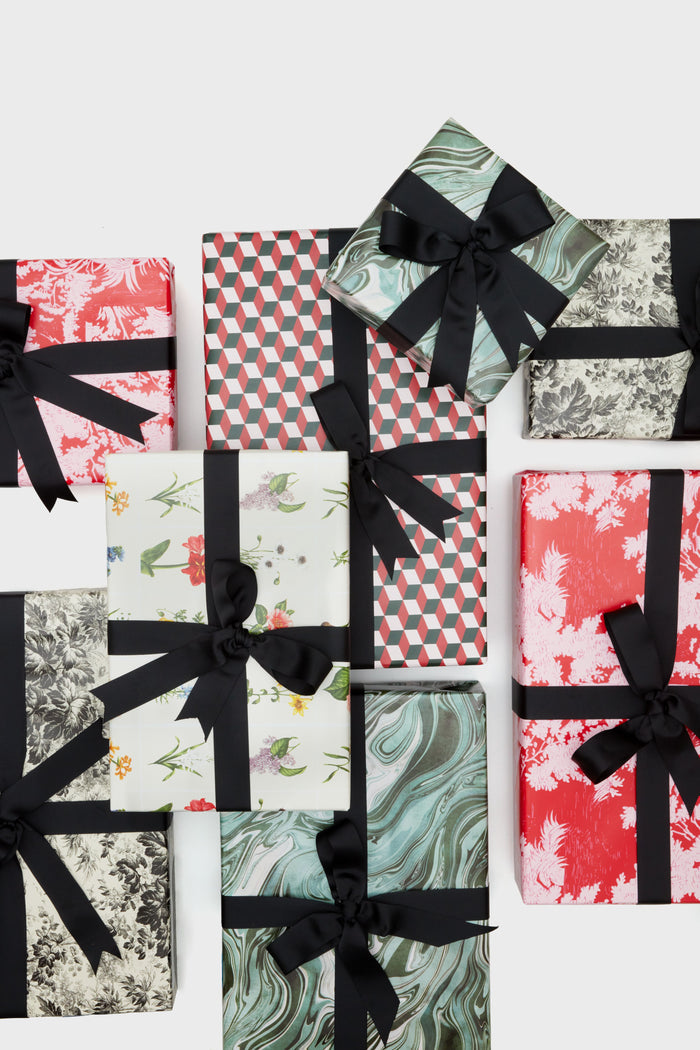 Stylishly arranged together, Supplies brand gift boxes feature various patterns and are neatly wrapped with black ribbon bows.