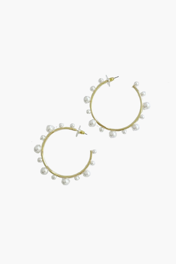 Nicola Bathie gold hoop earrings adorned with small faux pearls evenly spaced around the hoops, creating a bold and feminine jewelry statement.