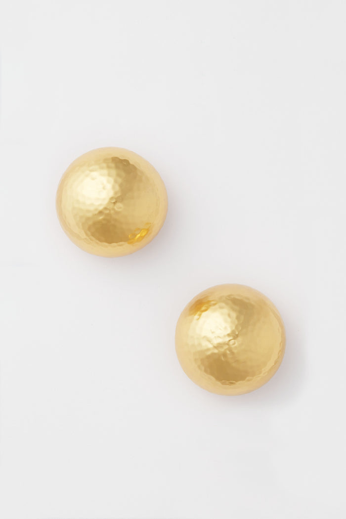 VALERE presents two round earrings with a hammered texture, crafted from 24K gold-plated metal and elegantly displayed.
