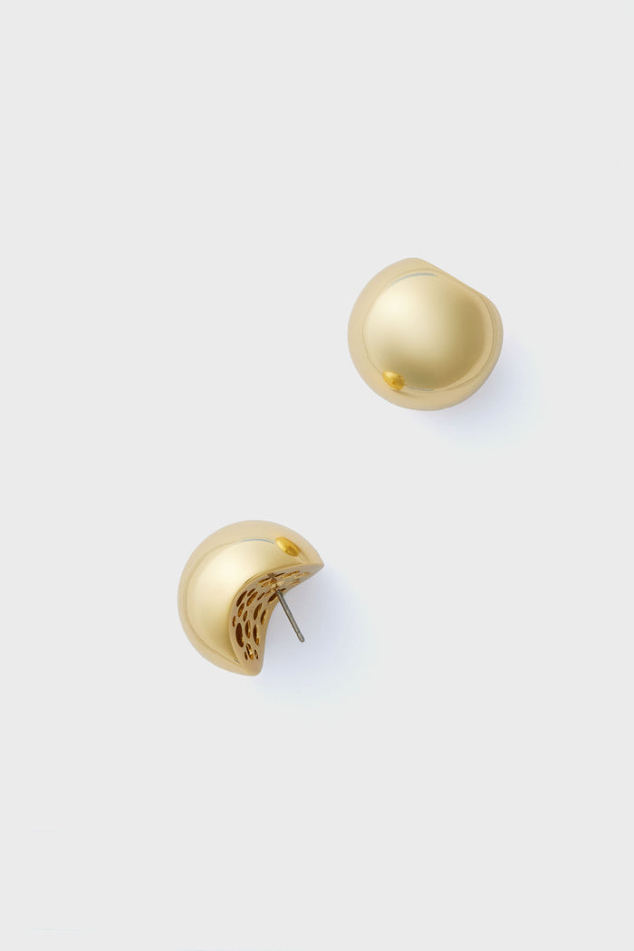 Tuckernuck Jewelry’s dome-shaped gold stud earrings feature smooth, shiny surfaces and an elegant design.