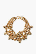 The Kenneth Jay Lane gold-plated beaded necklace features three rows of large, shiny, spherical beads and a rectangular clasp—an ideal statement piece for costume jewelry lovers.