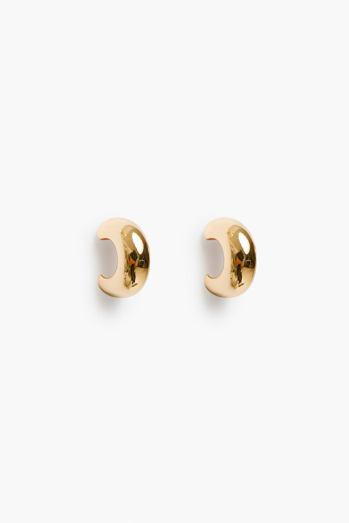 A pair of small, polished 18k gold plated ear cuffs with a smooth, curved design from Petit Moments, a woman-owned brand.