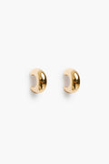 A pair of small, polished 18k gold plated ear cuffs with a smooth, curved design from Petit Moments, a woman-owned brand.