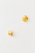 The image shows a pair of Tuckernuck Jewelry gold stud earrings with a classic knot design, crafted from nickel-free materials.