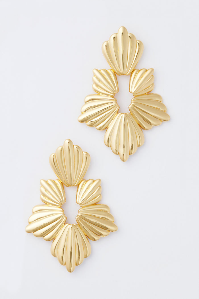 Two gold-toned, fan-shaped Gold Josie Earrings from Tuckernuck Jewelry are elegantly arranged.