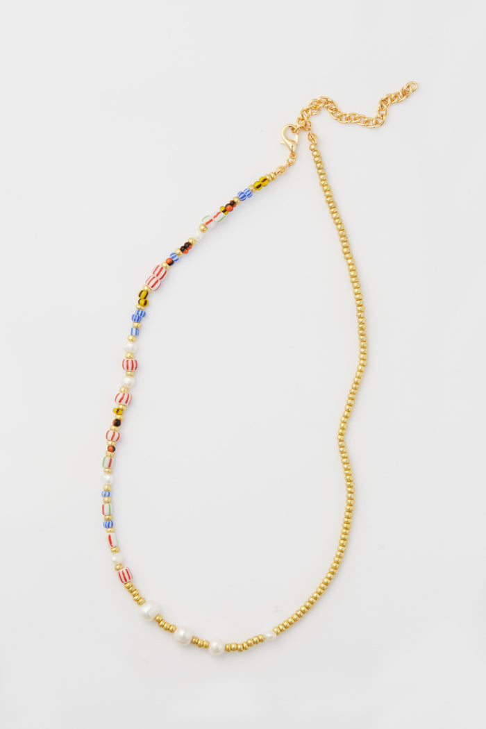 Petit Moments necklace featuring a mixed-media design with one half colorful beads, the other half small gold beads, finished with a gold chain and clasp.