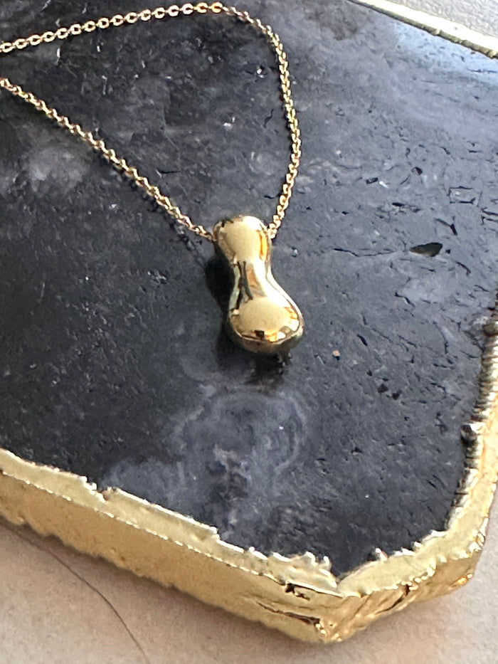 Gold letter I necklace on a stone plate