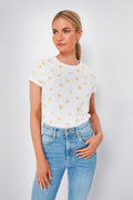 A woman wears a super-soft Marine Layer crew neck white t-shirt with yellow sun prints and light blue jeans.