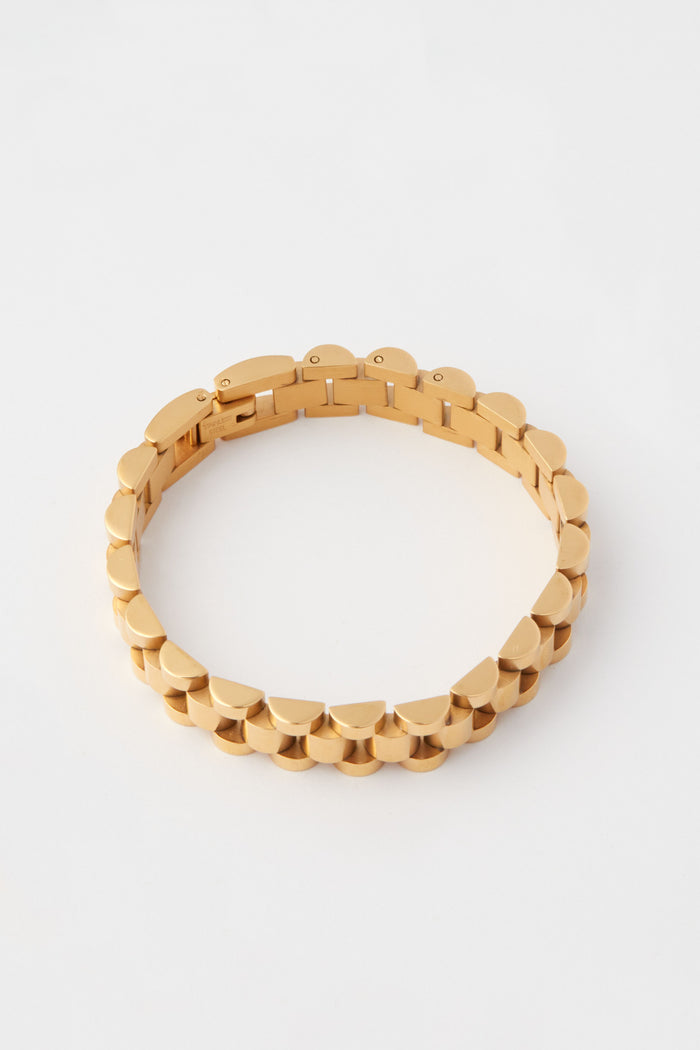 A geometric gold link chain bracelet from Petit Moments, crafted from 18k gold-plated stainless steel, is displayed.
