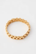 A geometric gold link chain bracelet from Petit Moments, crafted from 18k gold-plated stainless steel, is displayed.