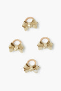 Juliska's four gold bow hair ties are elegantly arranged, each one resembling a chic table decor accent or a delicate gold napkin ring.