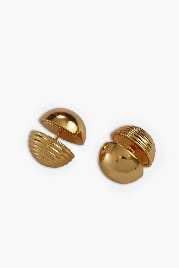 A pair of gold-toned, dome-shaped cufflinks by Cult Gaia, featuring ridged detailing on one half and crafted in a gold-plated brass finish inspired by the elegance of Gold Urbi Earrings.