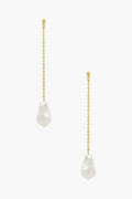The Petit Moments Gold Wren Earrings feature gold chains and irregular faux pearls at the ends, bringing a touch of elegance to any look.