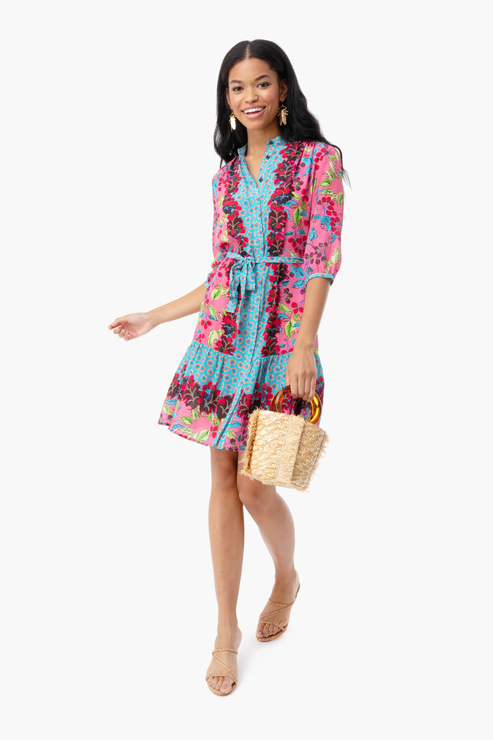 Young woman models an effortlessly chic look with Goldbug Large Drop Earrings, a floral dress, and a woven tote. A fun, high-end touch to her classic ensemble.