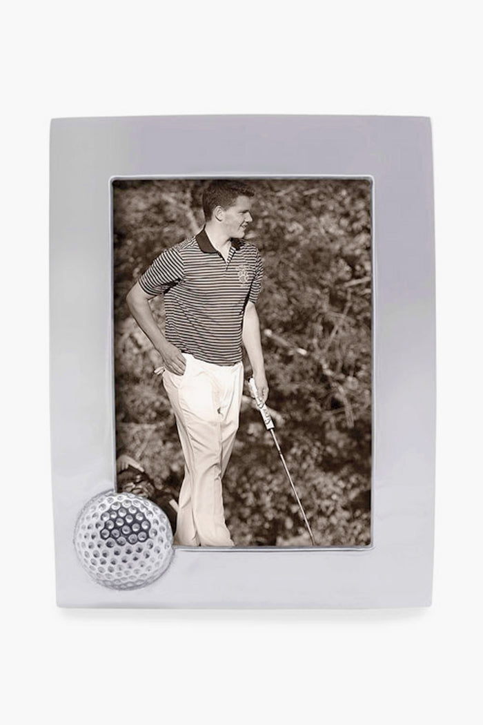 A black-and-white photo of a man in a striped polo and light pants holding a golf club, displayed in a handcrafted Mariposa golf ball frame.