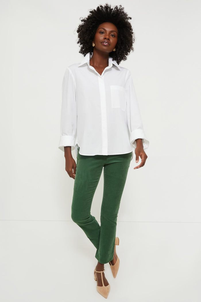 Model showcases Green Corduroy Ashford Pants, featuring a high rise and cropped kick hem, paired with a classic white shirt and nude T-strap heels for an effortless, high-end look.