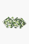 Four Chefanie Green Leaf Napkins, crafted from cotton with a charming leafy pattern and scalloped edges, are arranged in a row—perfect as a thoughtful housewarming gift.