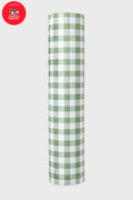 A roll of green and white checkered paper stands upright. A red circle in the top left features the Children’s National Hospital logo, echoing the lively design of the Tuckernuck x Jollie Green Trellis Yoga Mat.