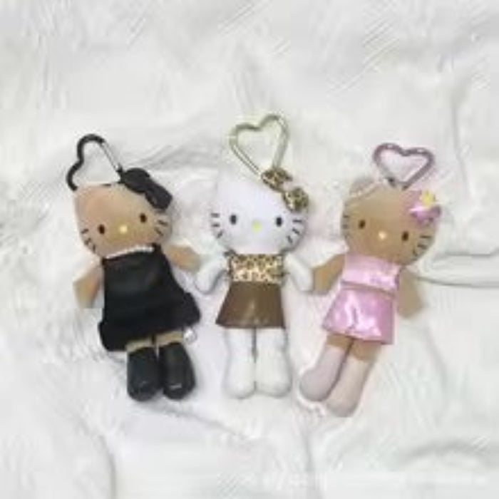 Three small plush toys resembling a cat, a bear, and a girl in different outfits on a white background.
