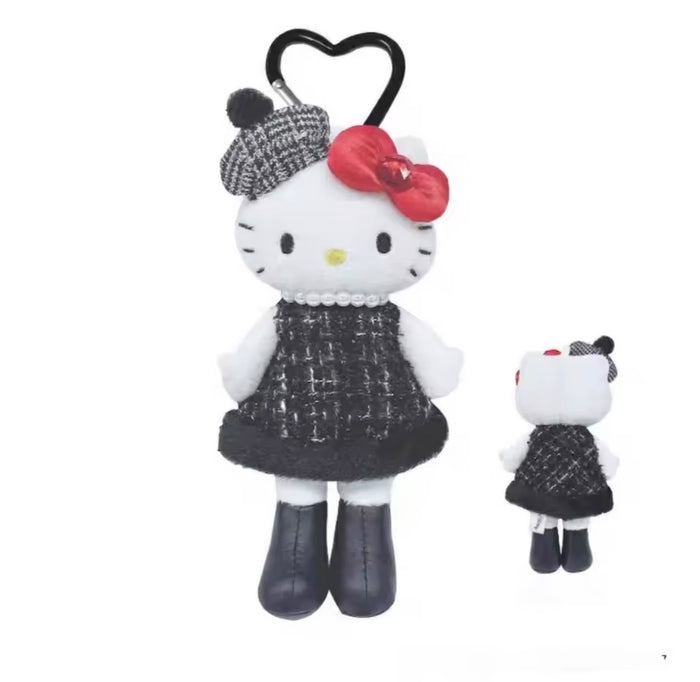 Hello Kitty plush toy with black dress and red bow, standing next to a smaller version on a white background.