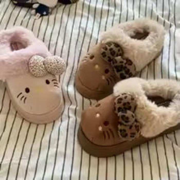Pair of adult slippers with cartoon designs on a striped background.