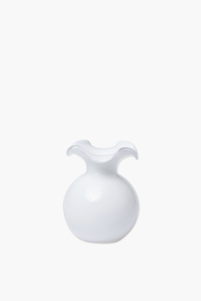 Handcrafted in Italy, the Vietri white glass vase features a round base and a wavy, flared rim for an elegant touch.