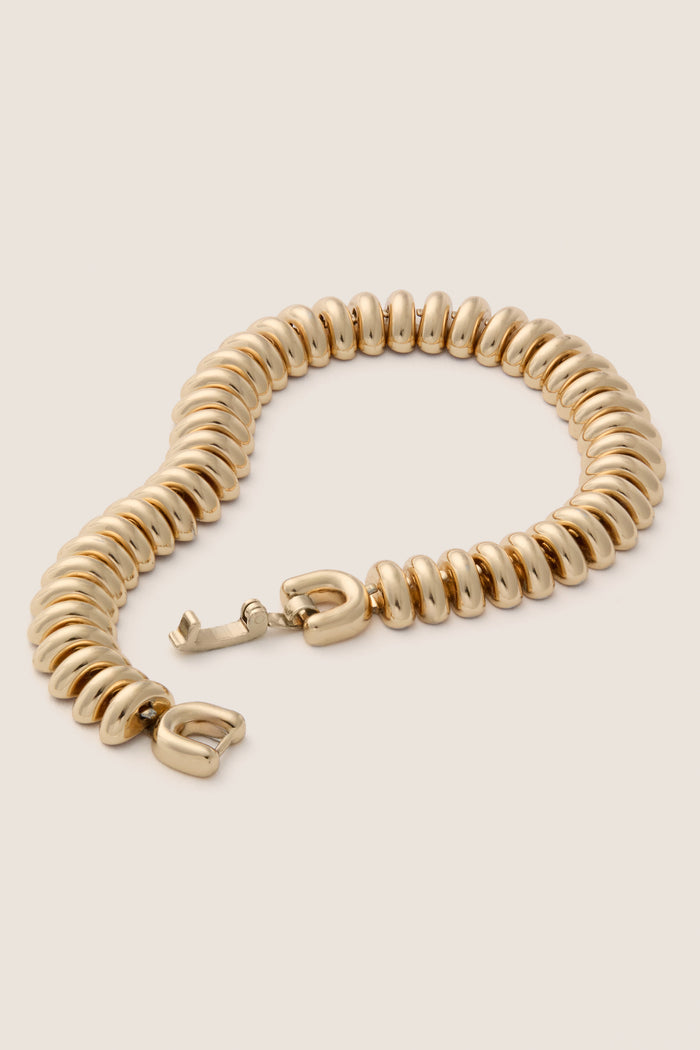 High Polish Gold Sofia Bracelet, a classic and high-end piece with a ribbed texture and caterpillar design, exudes effortless elegance in polished gold with a fun, foldover closure.
