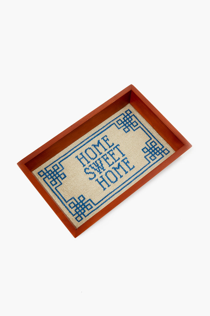 The Smathers and Branson rectangular needlepoint valet tray features a wooden border and hand-stitched fabric center reading HOME SWEET HOME in blue with a geometric frame—a perfect housewarming gift.