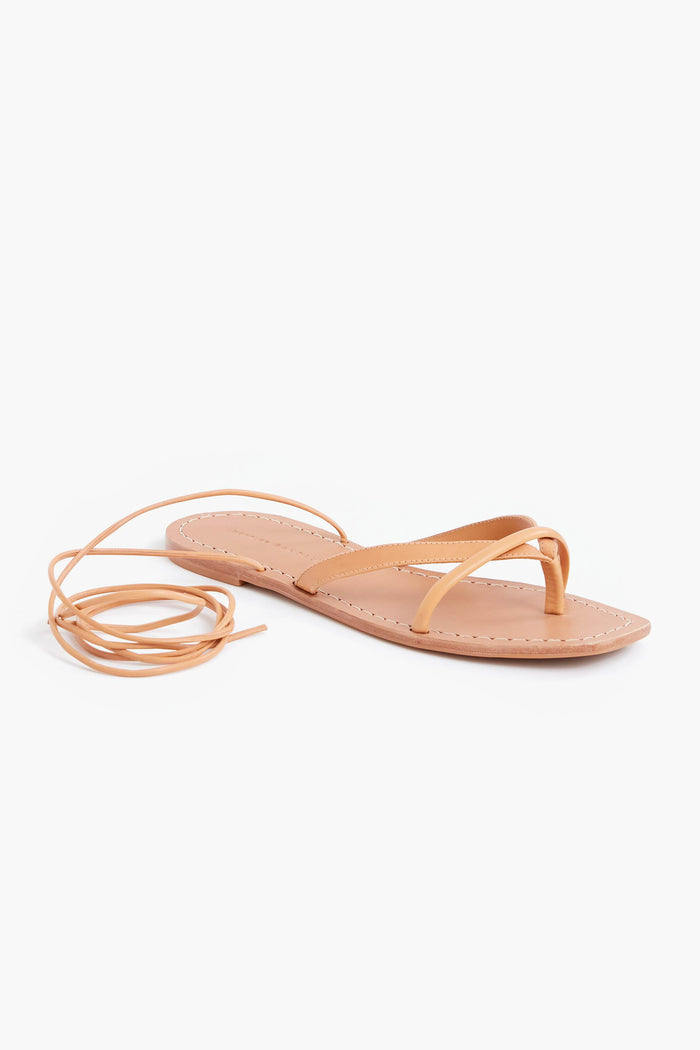 The Loeffler Randall Honey Lilla Thong Sandal features thin tan crisscross straps and a long ankle wrap lace, making it a stylish leather sandal choice.