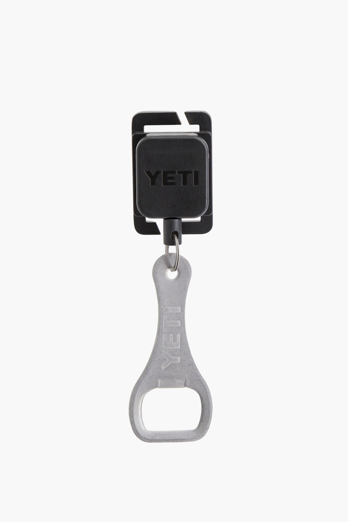 The YETI metal bottle opener is attached to a black retractable keychain holder, making it easy to access on your YETI cooler or Hopper Molle Zinger.