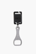 The YETI metal bottle opener is attached to a black retractable keychain holder, making it easy to access on your YETI cooler or Hopper Molle Zinger.